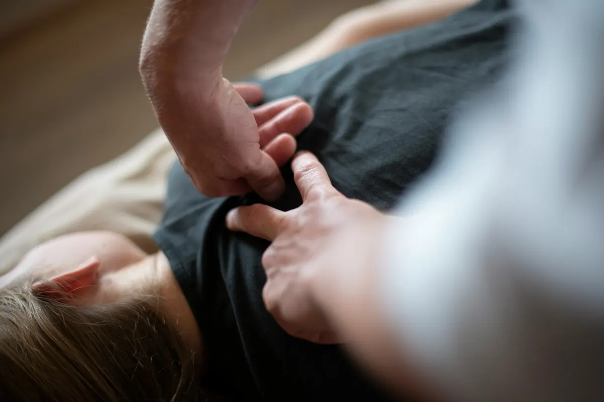 Manos de un fisioterapeuta tratando la espalda de una paciente