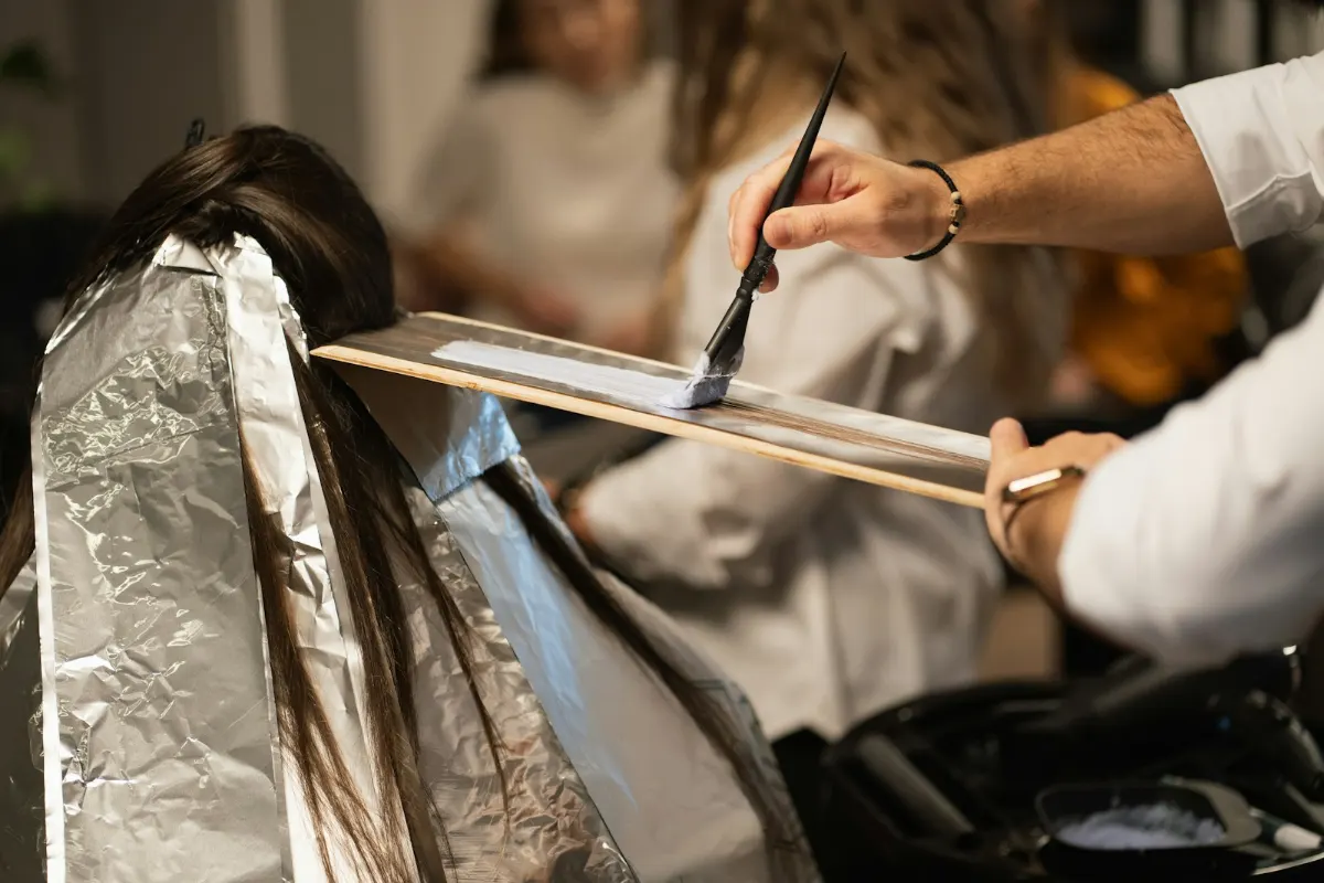 Peluquero aplicando mechas con las dos manos ocupadas